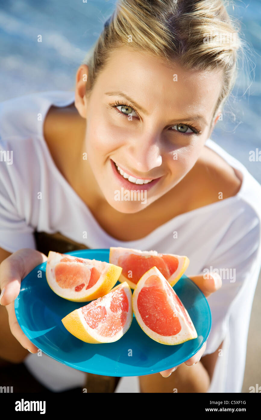 young healthy female with plate of pink grapefruit Stock Photo