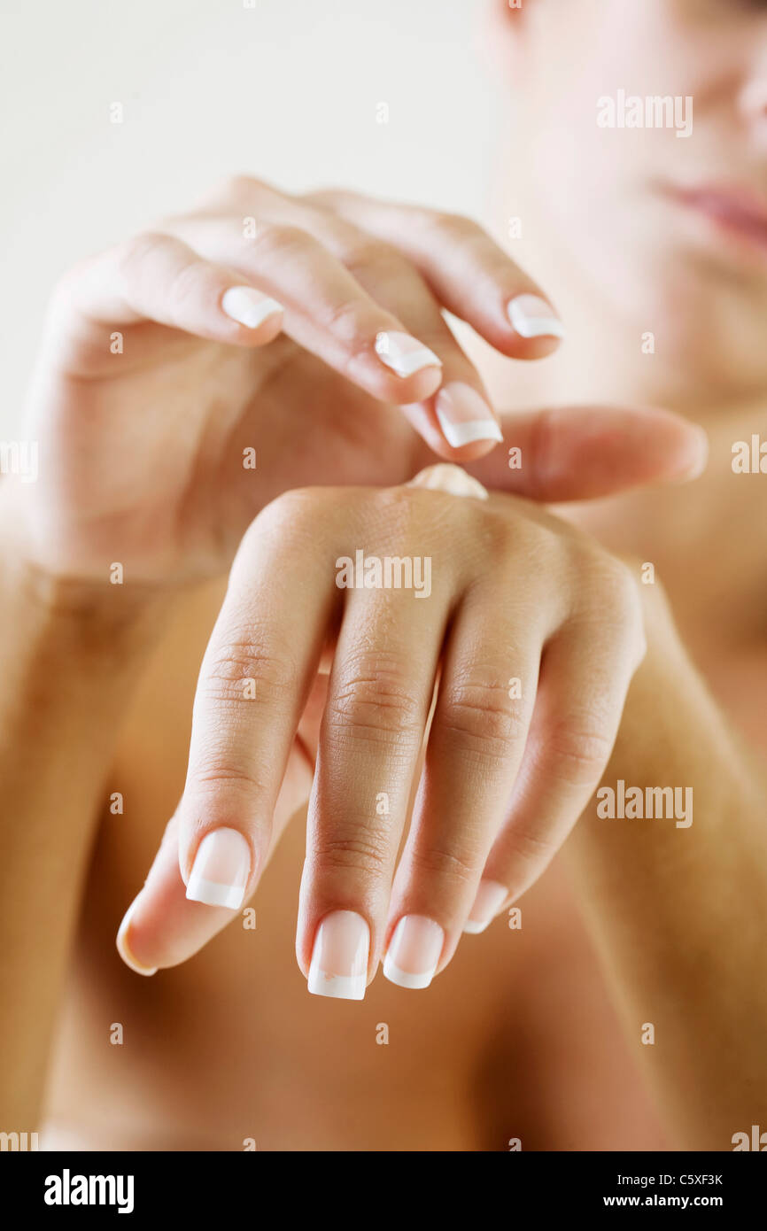female applying cream to her hands Stock Photo