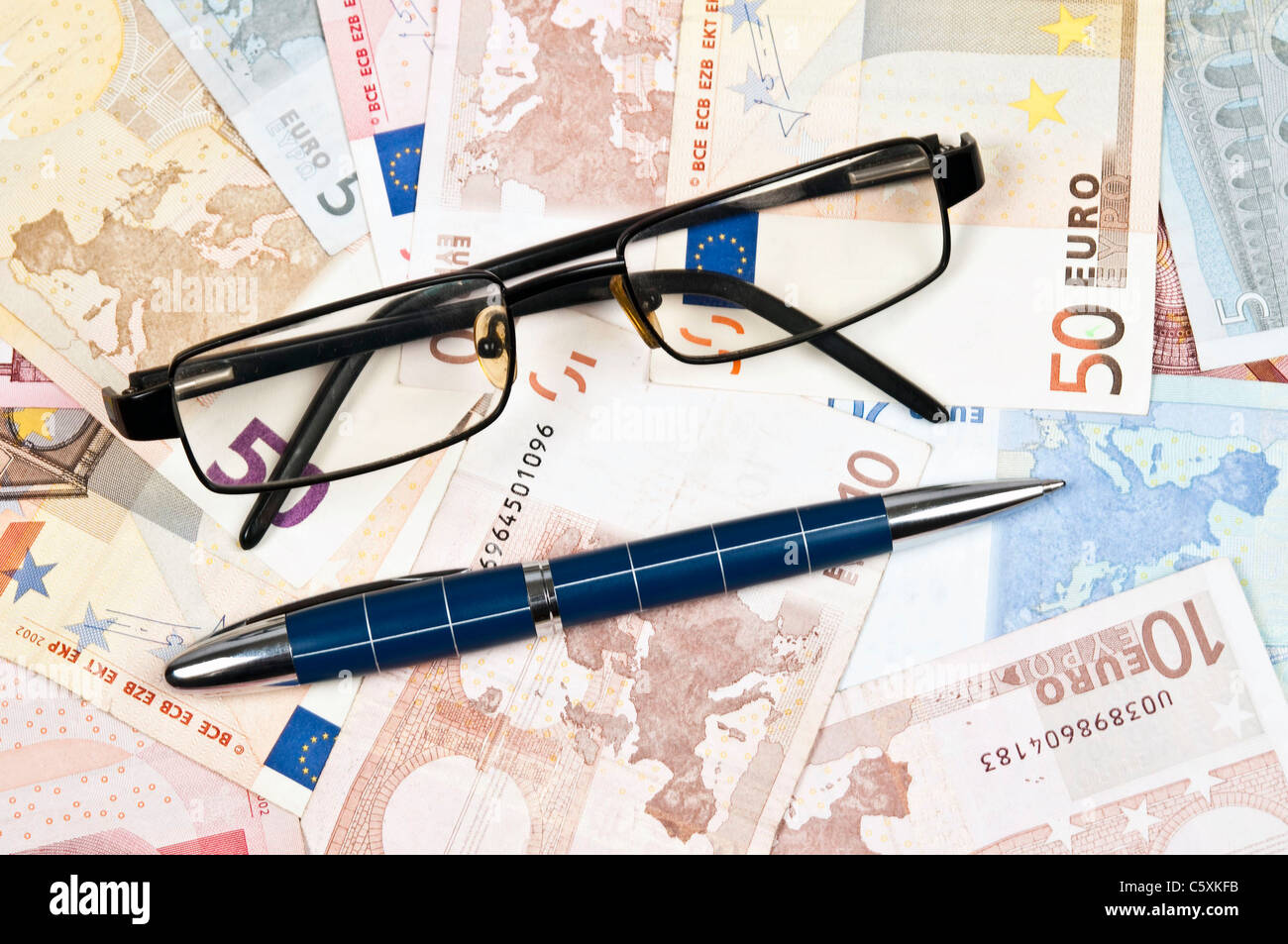 Eye glasses on euro banknotes Stock Photo