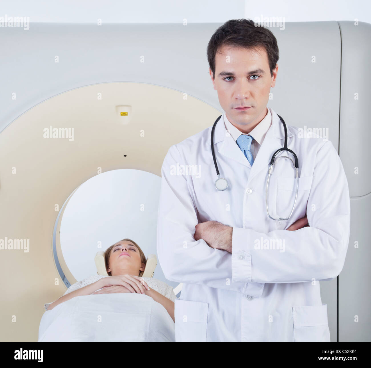 Serious doctor looking at camera in front of ct scanner Stock Photo