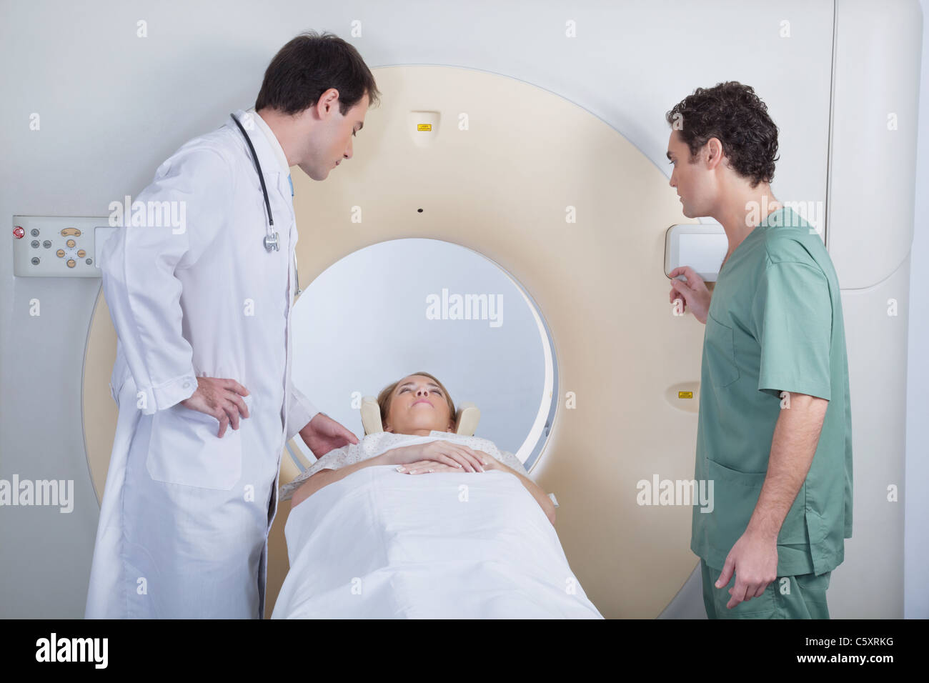 Doctor with technician examining patient before CT scan test Stock Photo