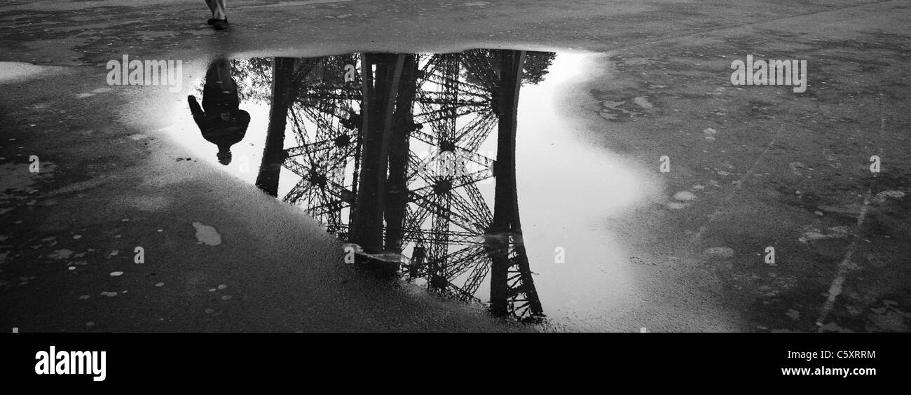 A panoramic photograph of the Eiffel Tower Paris France Parisian reflected in a puddle near the tower. Stock Photo