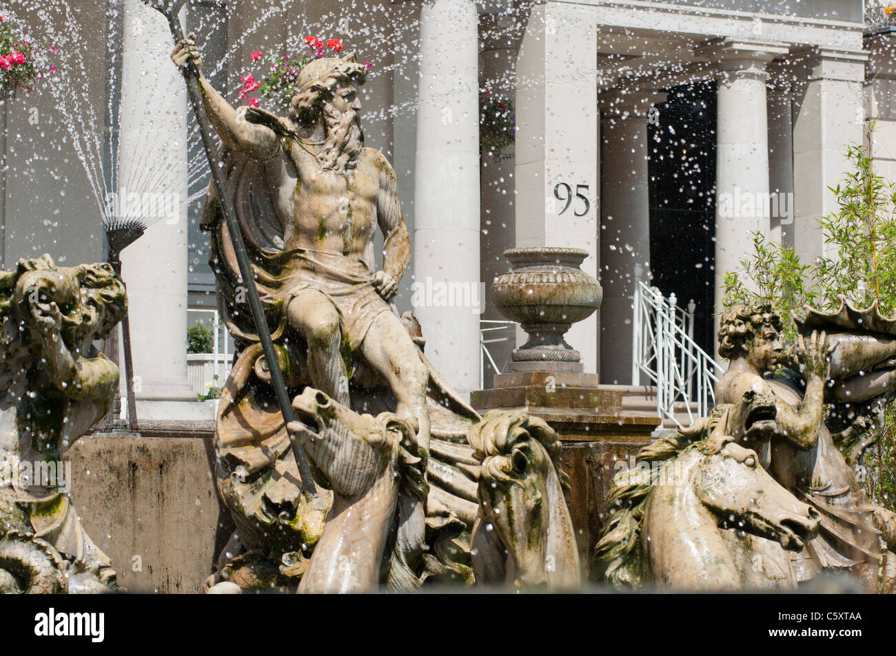 The Neptune fountain in the foreground with the Municipal Offices in The Promenade at Cheltenham, Gloucestershire. Stock Photo
