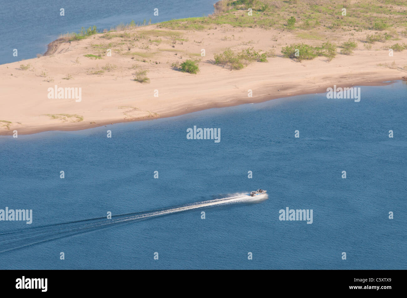 Motor boat in Volga river goes by a sand beach of Zelenenky island near Samara Stock Photo