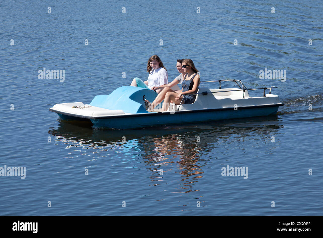 three girls in a pedalo on Lake Gartow, Nature Reserve ElbuferDrawehn, Lower Saxony, Germany