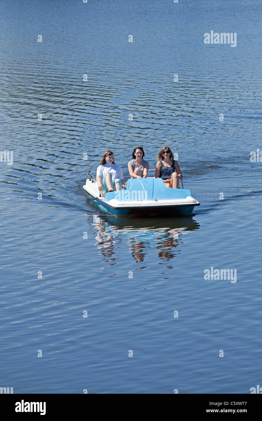 three girls in a pedalo on Lake Gartow, Nature Reserve ElbuferDrawehn, Lower Saxony, Germany