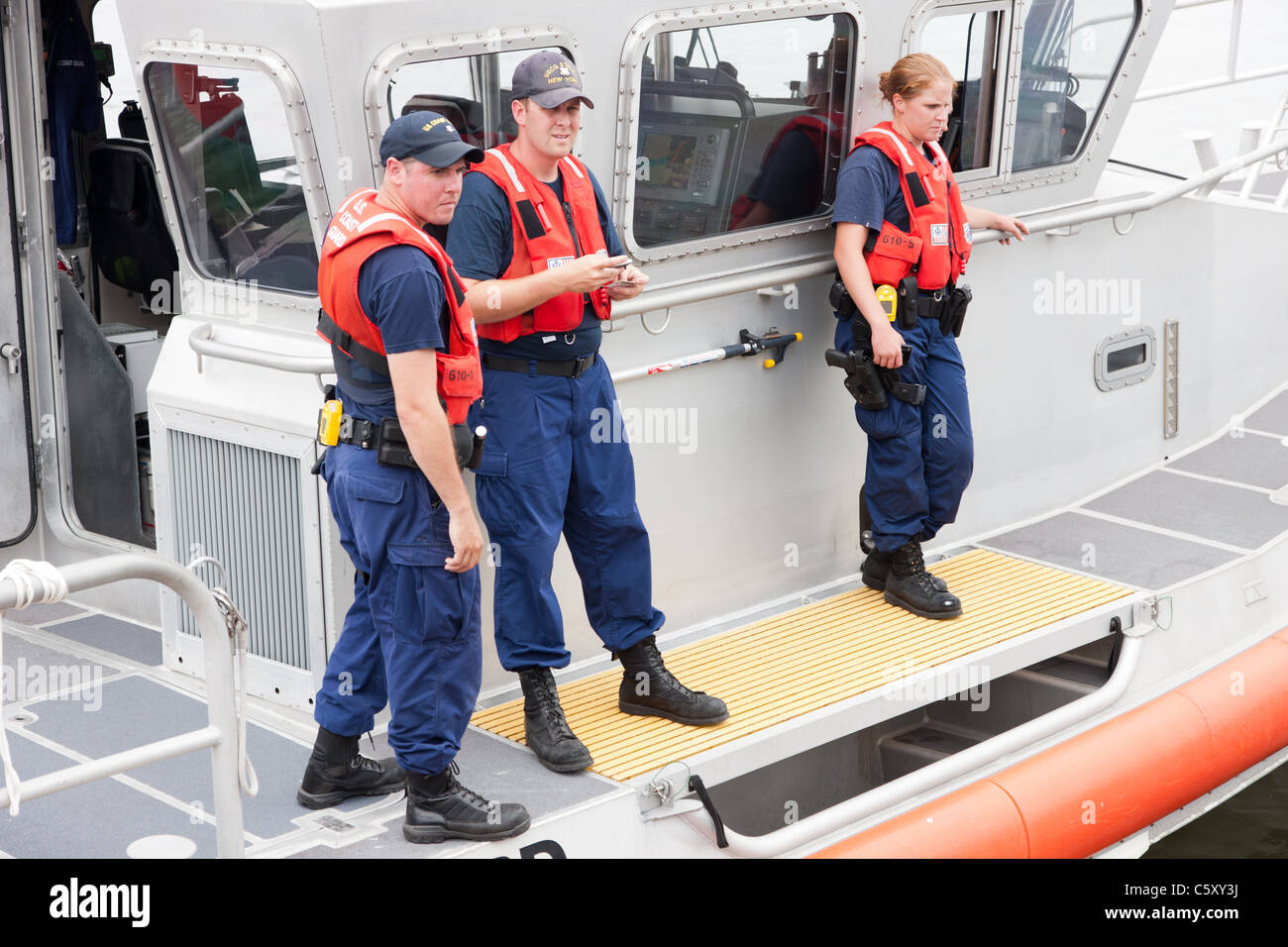 The crew of the US Coast Guard Response Boat-Medium (RB-M) 45610 helps a stranded boater on Kill Van Kull in Bayonne, New Jersey. Stock Photo