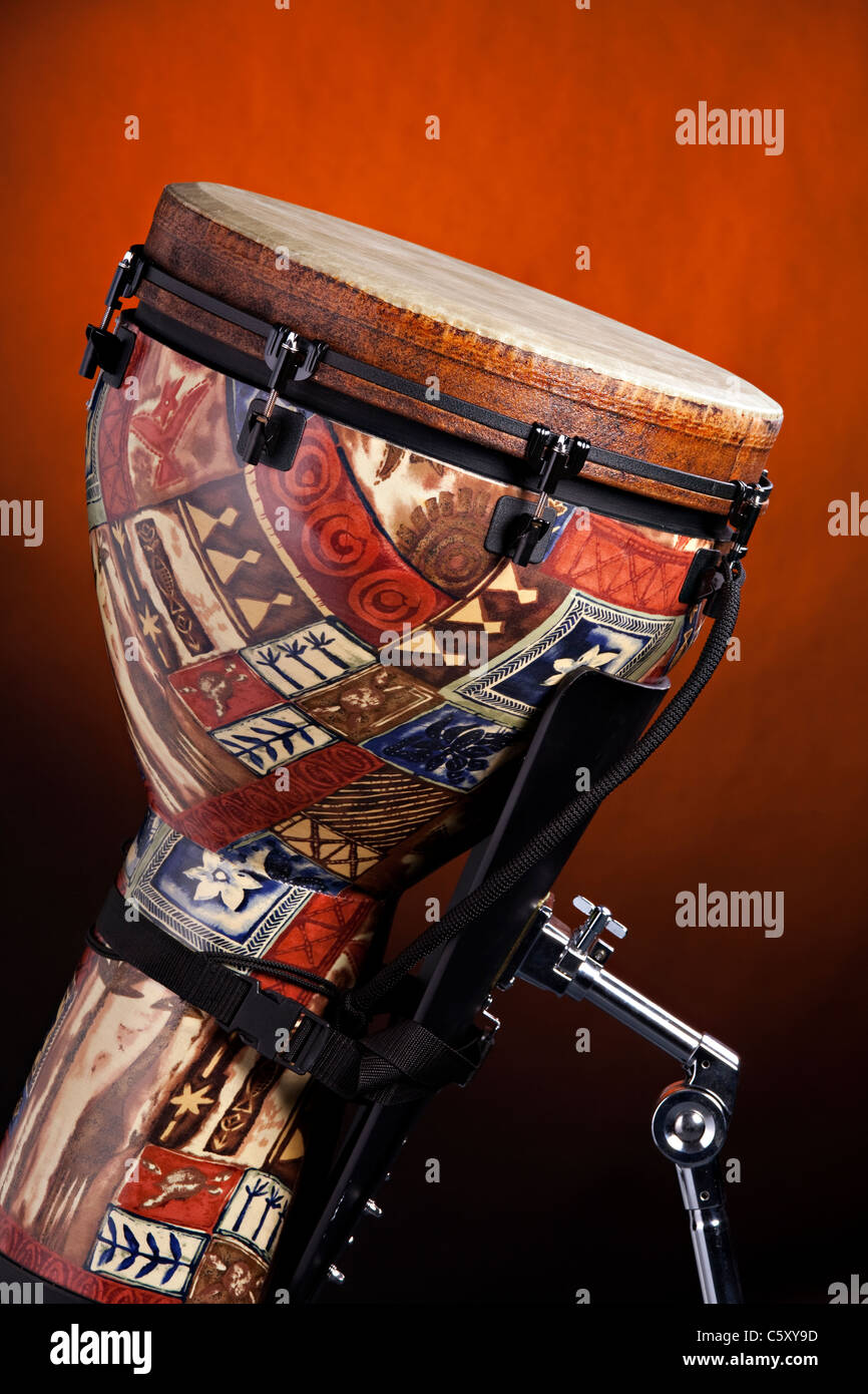 An African or Latin djembe drum isolated against a spotlight gold