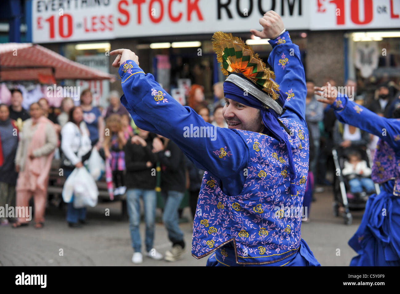 Happy Bhangra dancers in traditional Indian costume dancing infront of a crowd in West Bromwich High Street Stock Photo