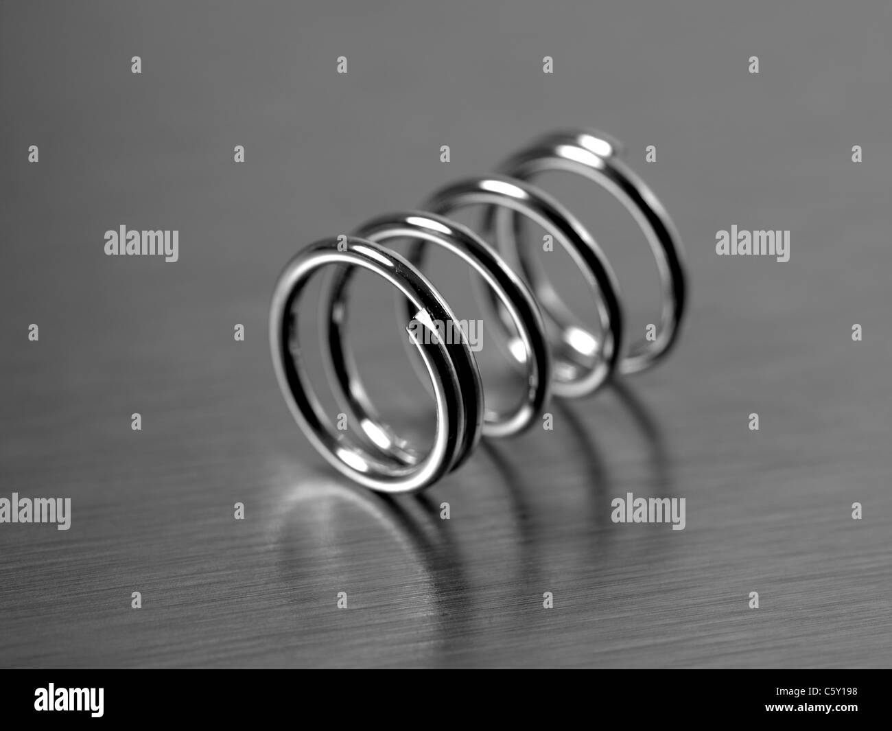 A spring isolated against a silver background Stock Photo - Alamy