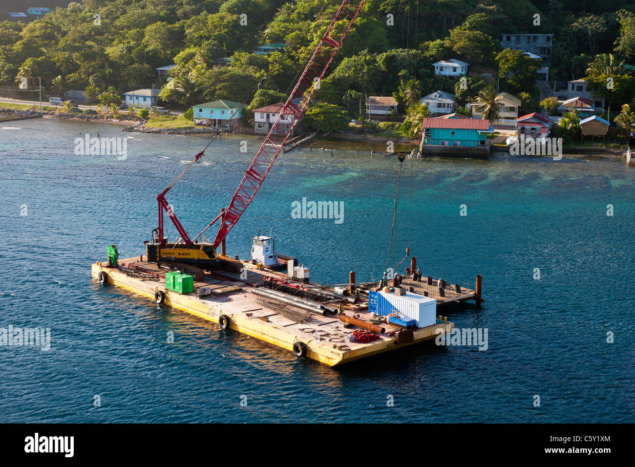 Construction crane barge crew building new mooring block at the cruise ship port on the island of Roatan, in Honduras Stock Photo