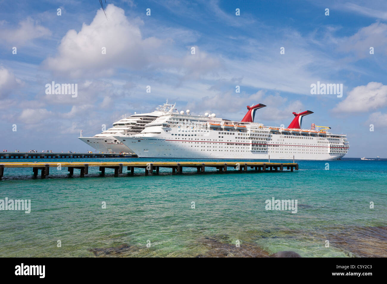 Cruise ship passengers on pier disembarking from Carnival cruise ships Triumph and Ecstasy in Cozumel, Mexico Stock Photo