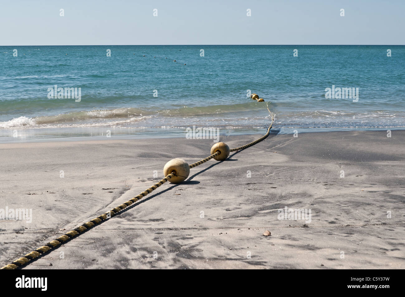 String of marker buoys on sandy beach in Panama Stock Photo