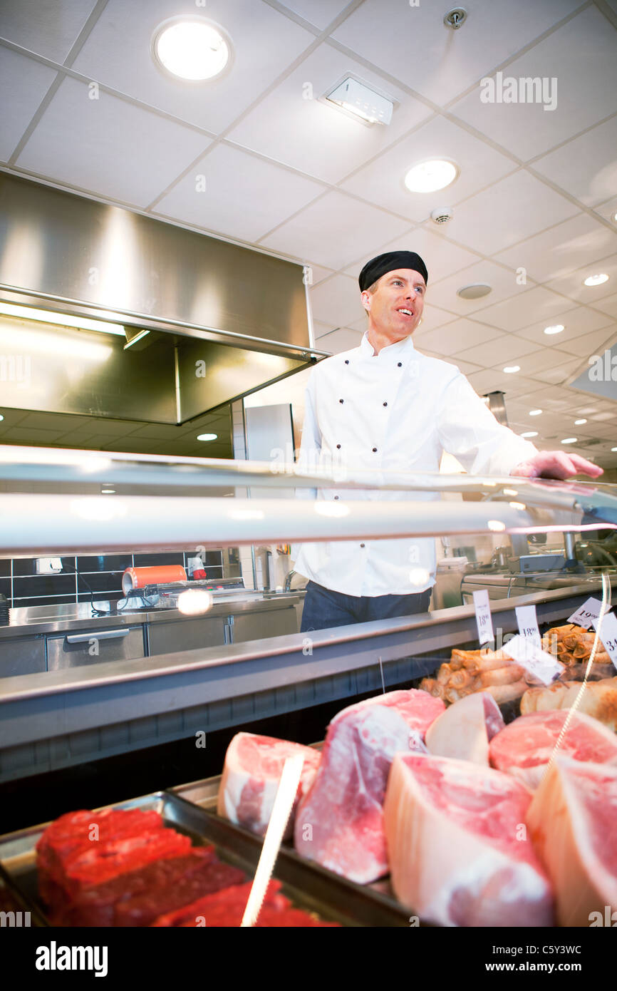 A butcher helping a customer at a fresh meat counter or deli Stock ...