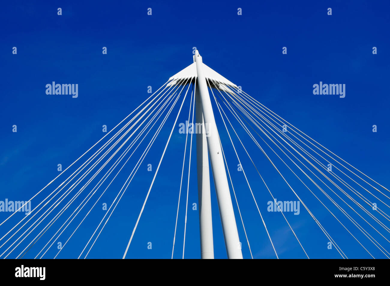 Geometric abstract architecture cluster of suspension bridge wire cables deep blue sky background pointing upwards in a triangle shape England UK Stock Photo