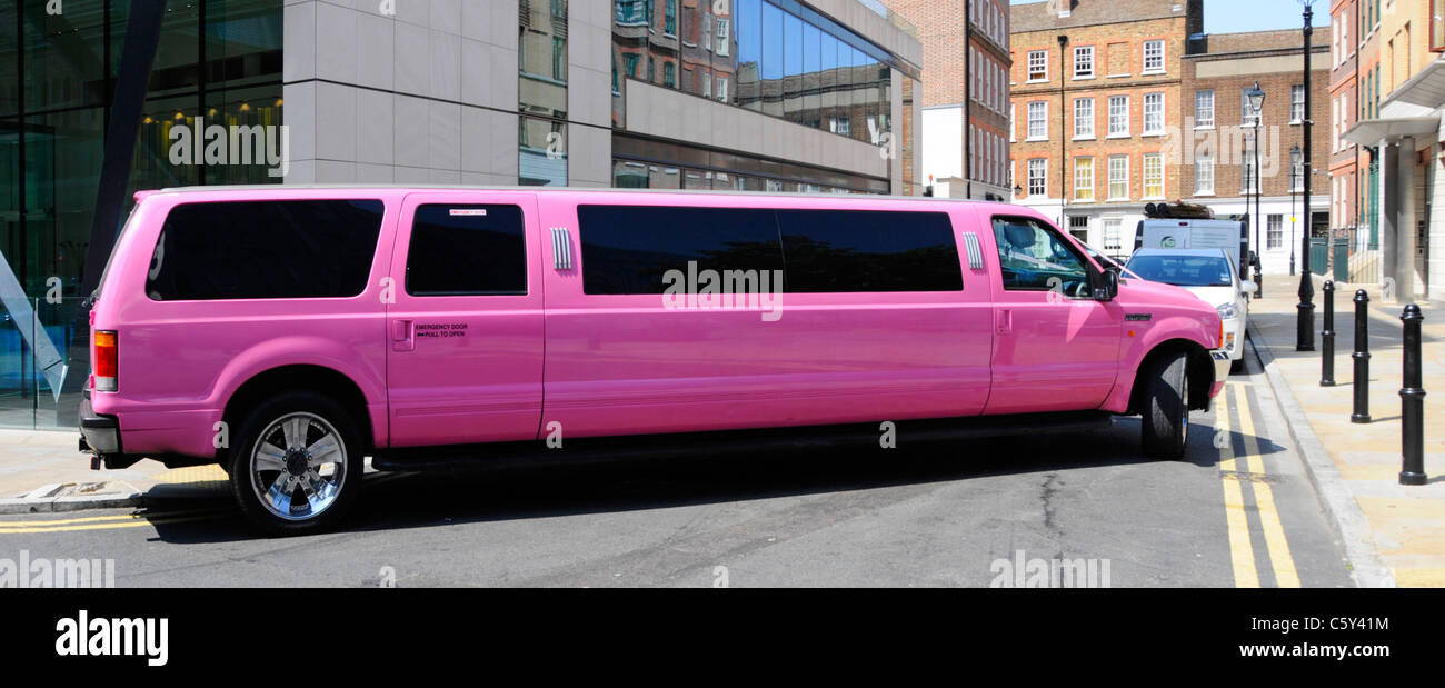 Pink stretch limousine hire car in the City of London providing transport for a wedding England UK (adverts & number plates digitally removed) Stock Photo