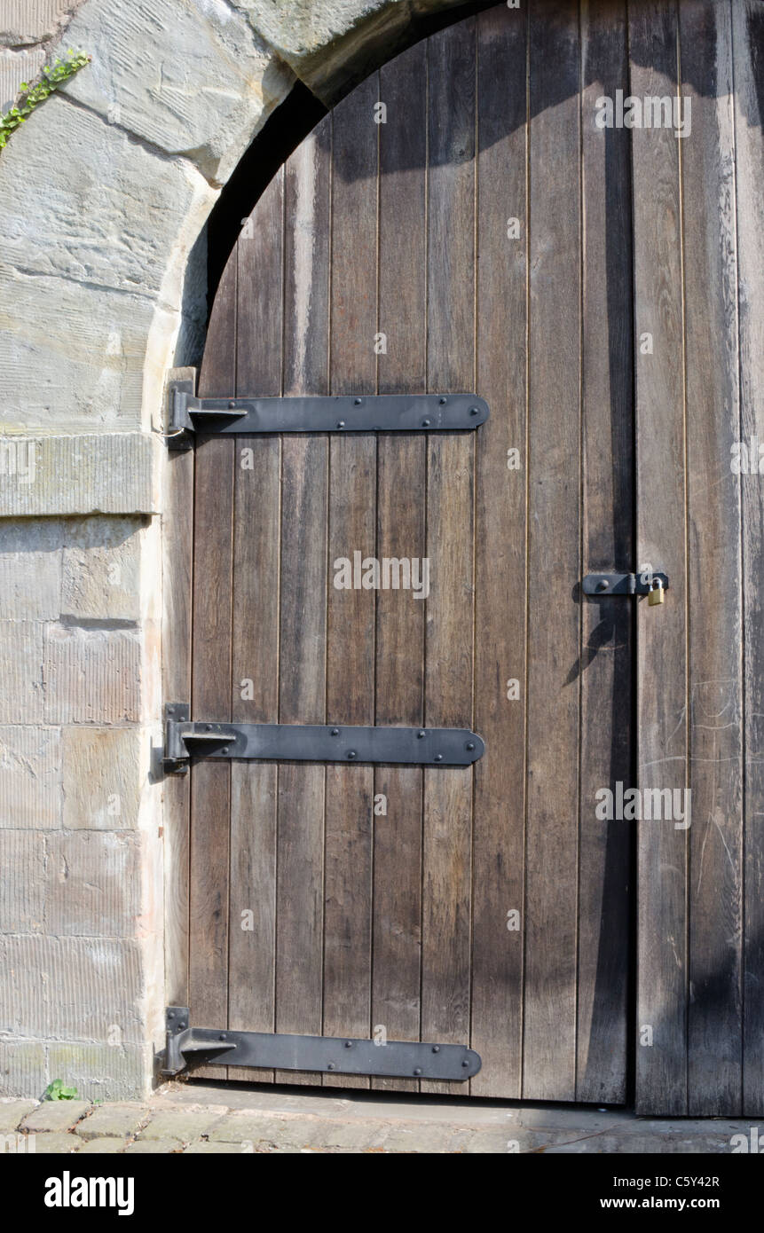 Curved wooden door in an arch beside the Iron bridge, Shropshire, England, UK Stock Photo