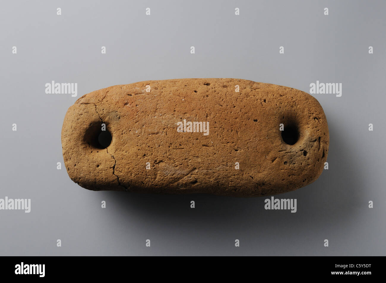 Loom weight with two holes made in earthenware. Chalcolithic period  in  ' Burgo de Santiuste Museum'- SPAIN Stock Photo