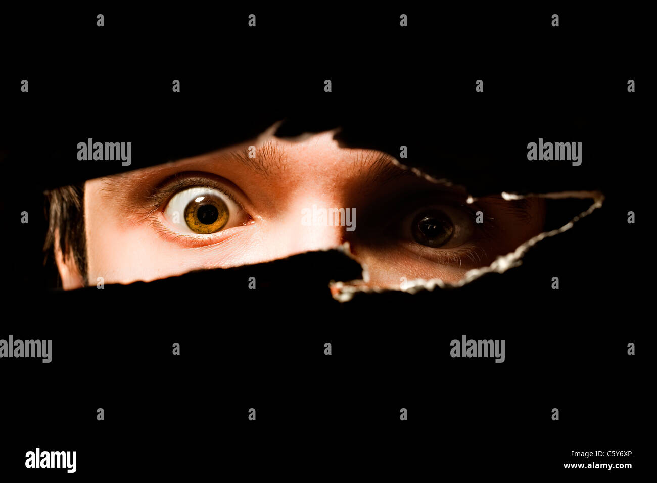 Man spying through hole in hires stock photography and images Alamy