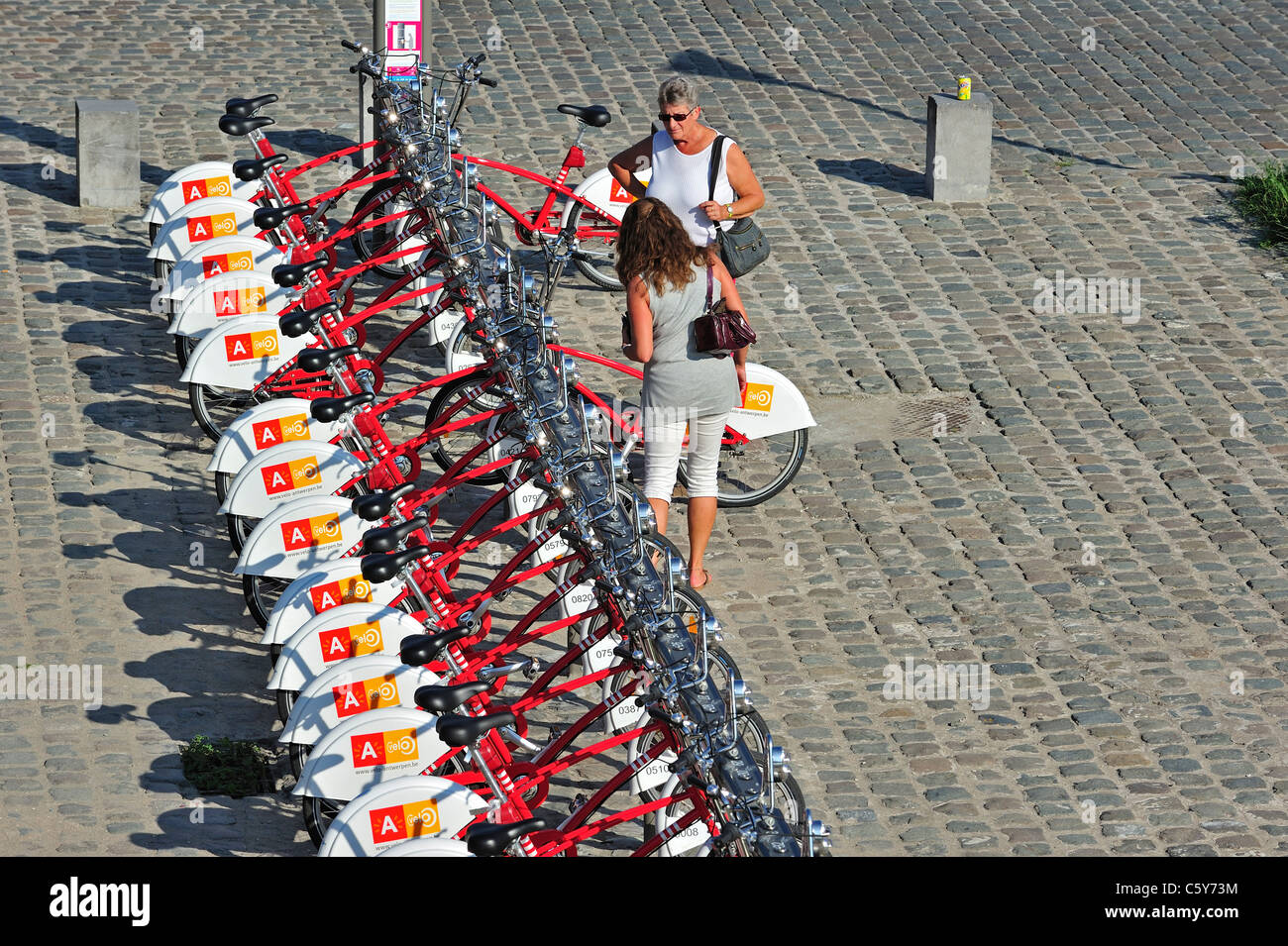 Parked red bicycles in one of the Velo stations at Antwerp city, Belgium Stock Photo