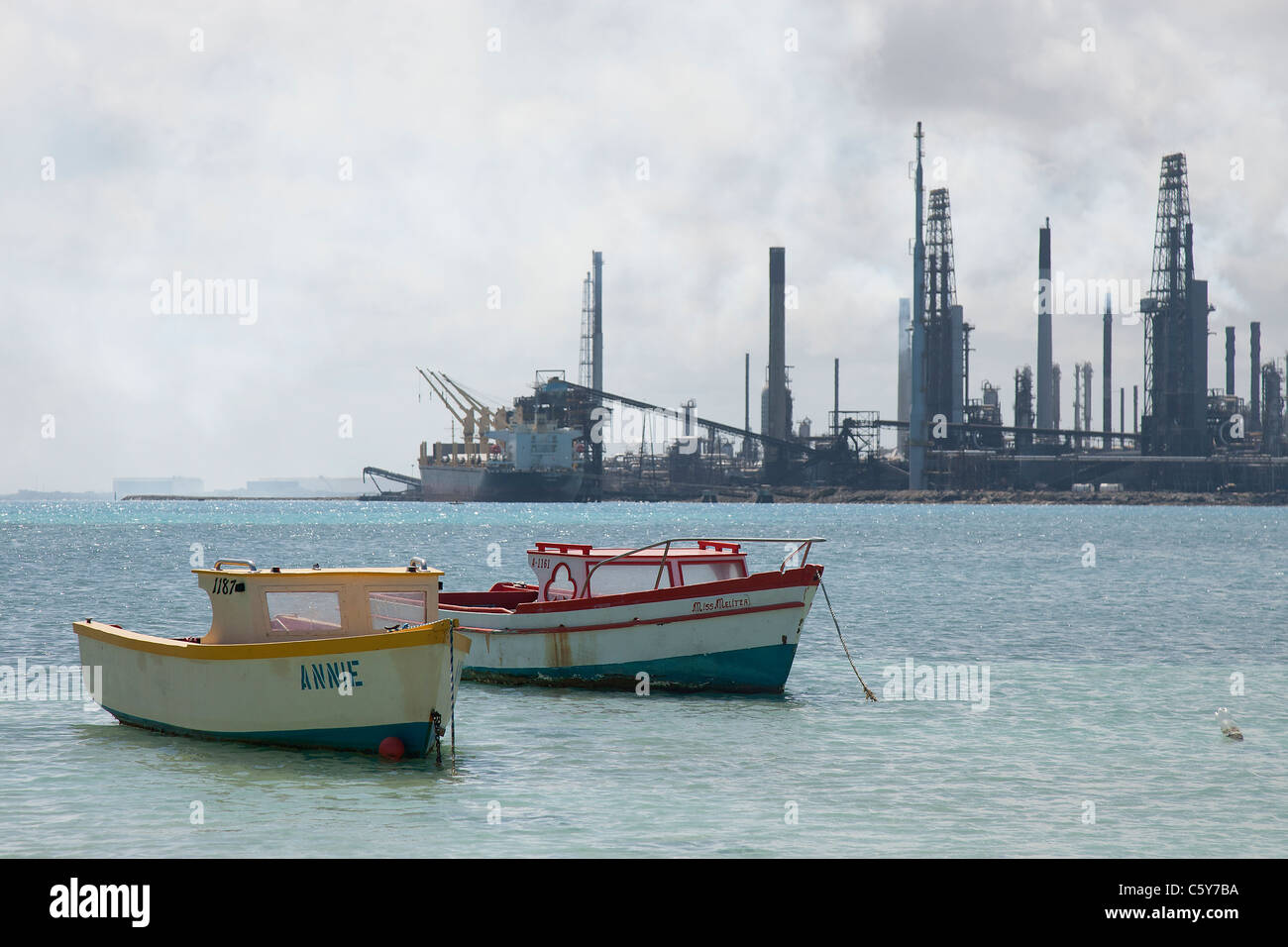 Fishing boats in a bay with the Valero Oil Refinery in the background, Aruba, Dutch Caribbean Stock Photo