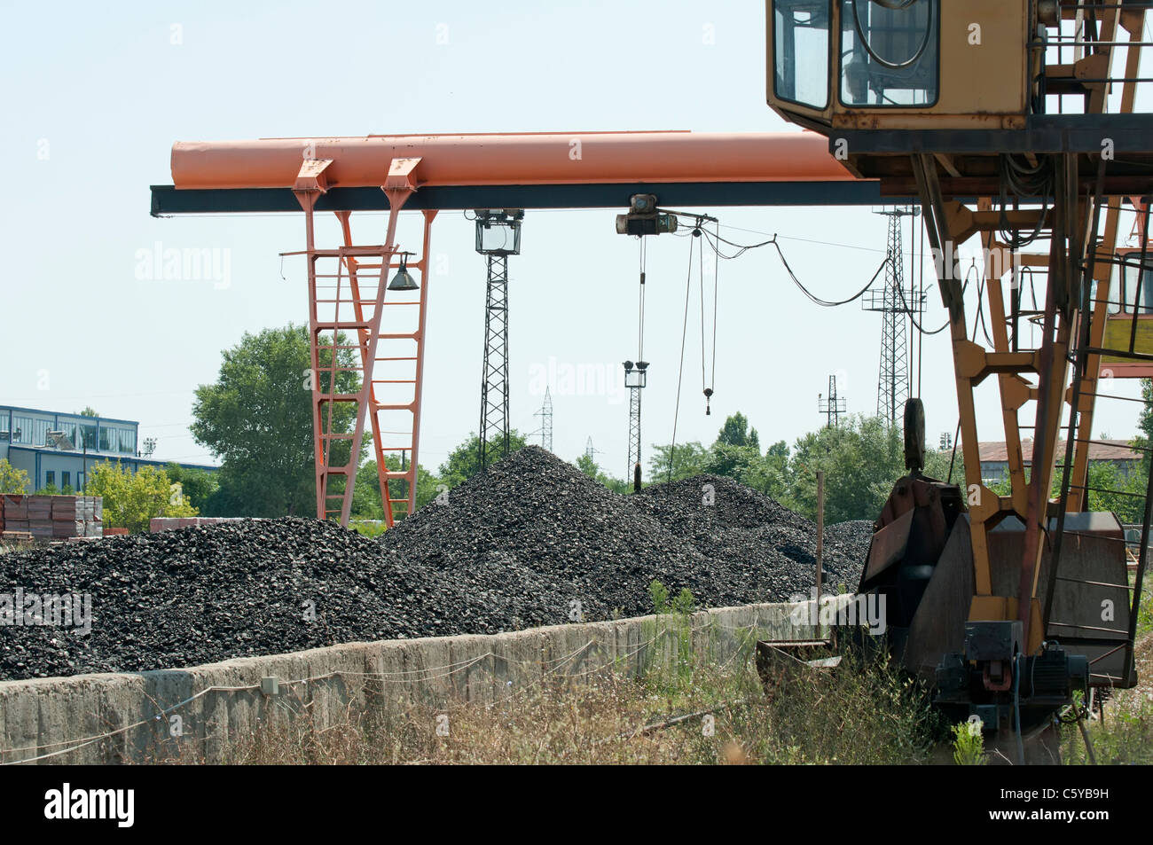 Crane and piles of coal. Lading base Stock Photo