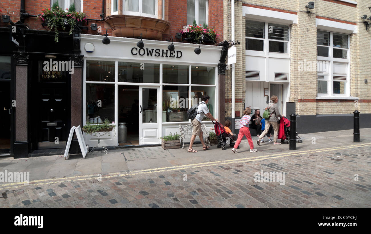 A family visiting the Carnaby Street area of London walking past spa concept store Cowshed Carnaby, Soho London England UK Stock Photo
