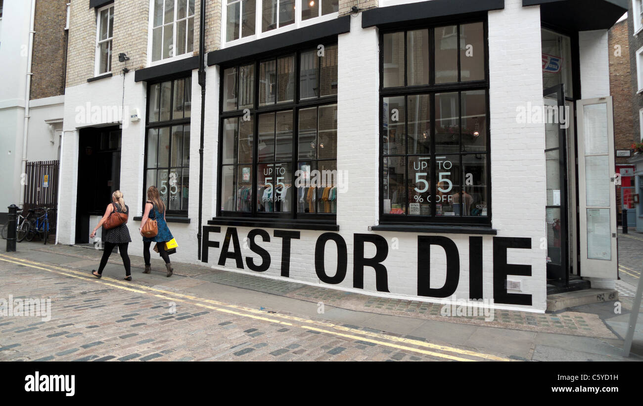 Shoppers on cobblestone street walking past 'Fast or Die' boutique on Newburgh Street near Carnaby Street London England UK Stock Photo