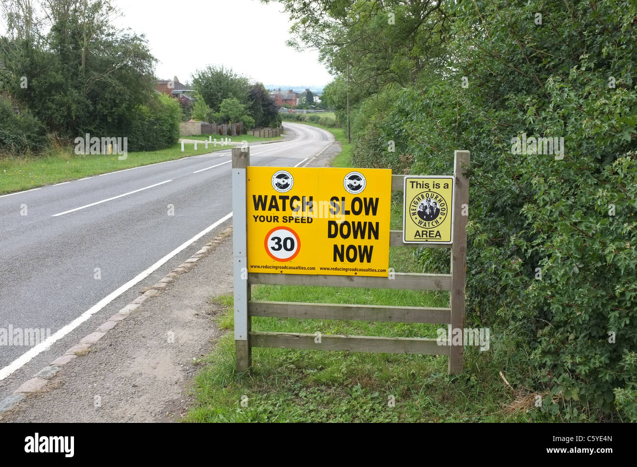 Neighbourhood watch sign and speed limit warning signs at the entrance to the rural village of Sutton Bassett Stock Photo