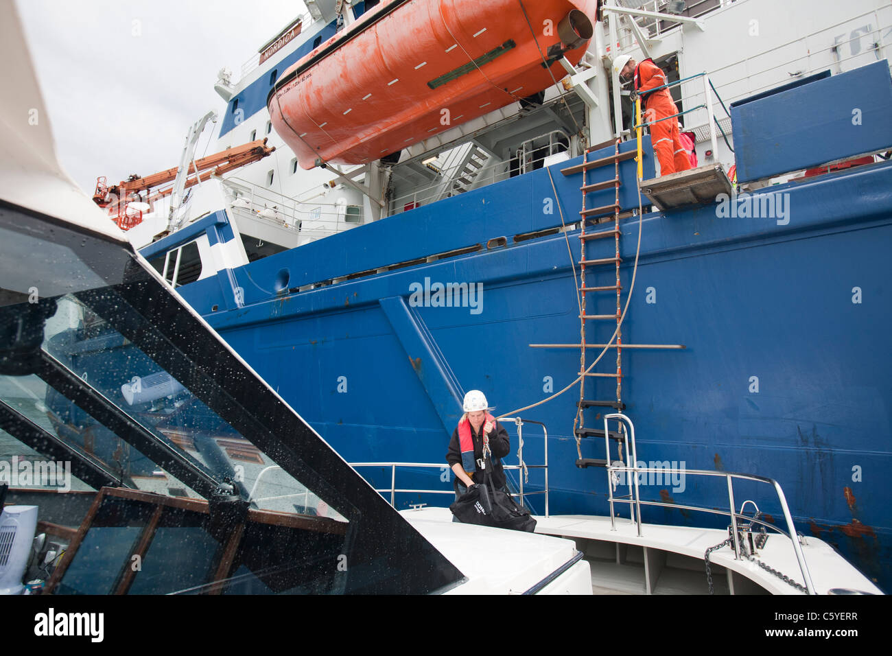 Wind turbine construction workers being transferred from a cable laying vessel back to shore, Cumbria, UK. Stock Photo