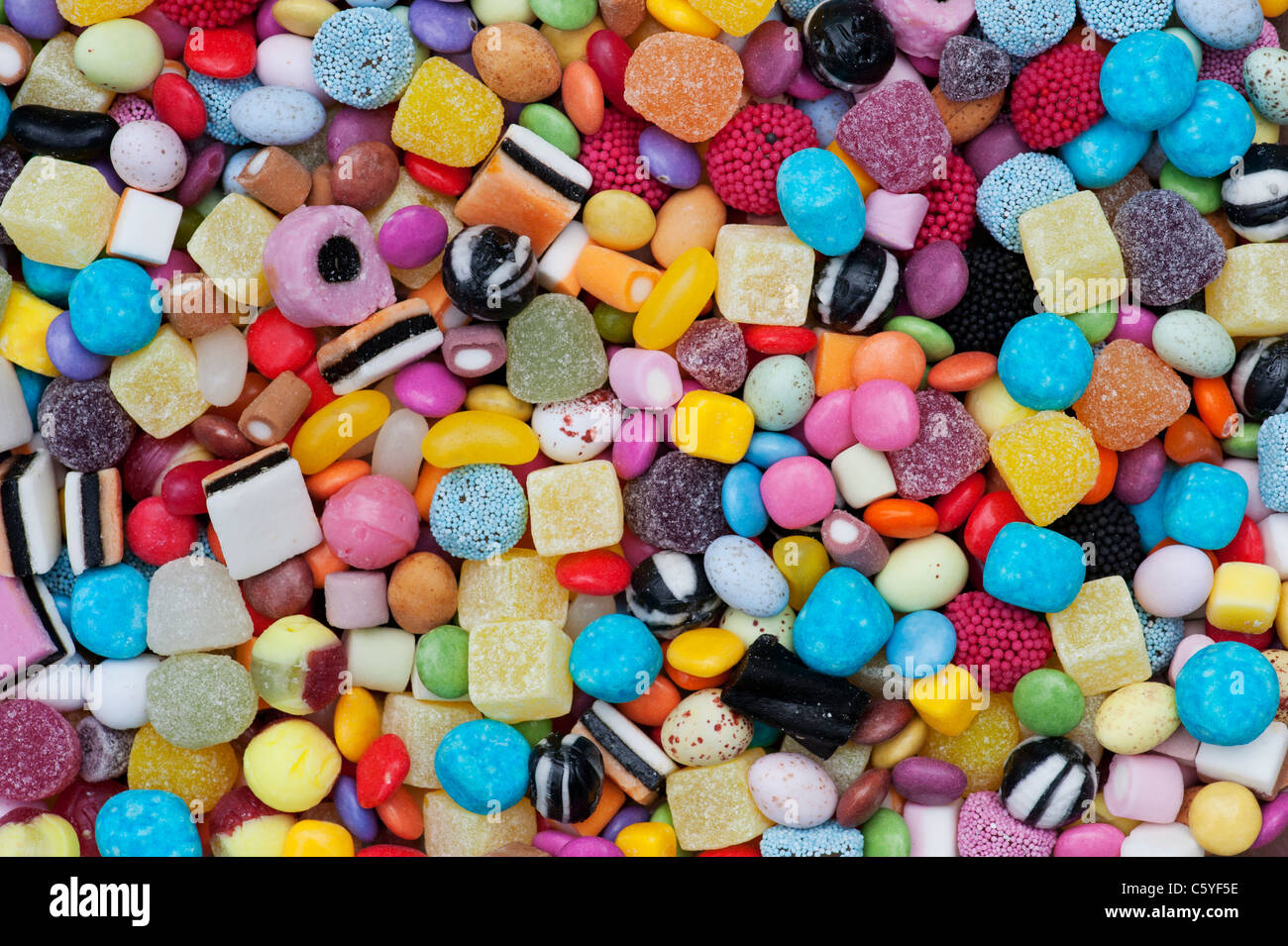 Colourful childrens sweets pattern. Liquorice allsorts, Smarties, pineapple cubes, humbugs, bonbons, dolly mixtures and jelly beans Stock Photo