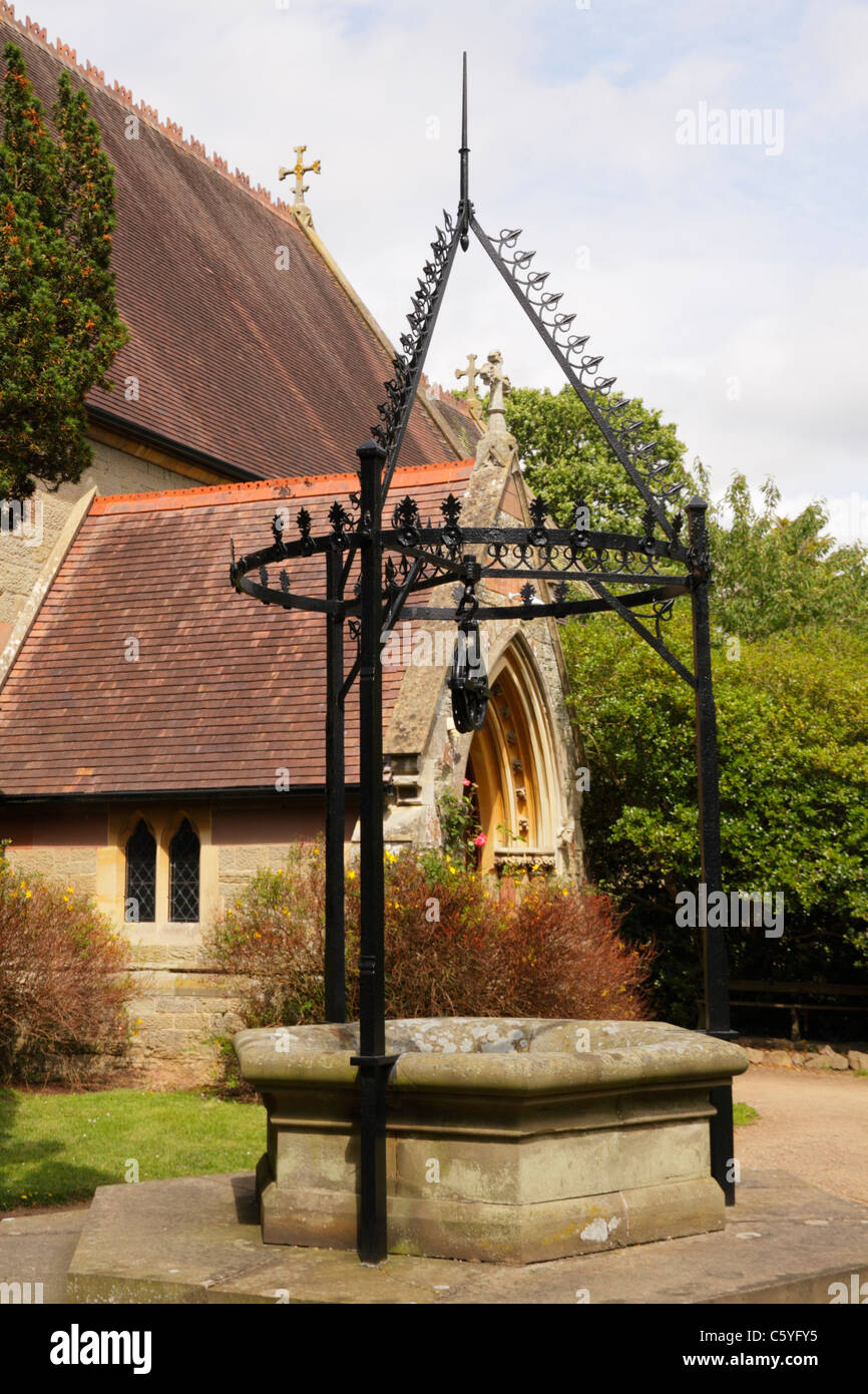 Churchyard of St Mary the Virgin, Madresfield Church, with  churchyard well with wrought iron pulley and surround. Madresfield. Stock Photo
