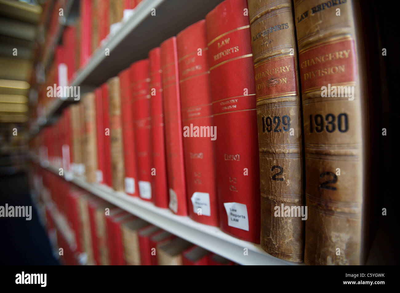 Old law book spines showing 1929 and 1930 on a library shelf with rows of red books Stock Photo