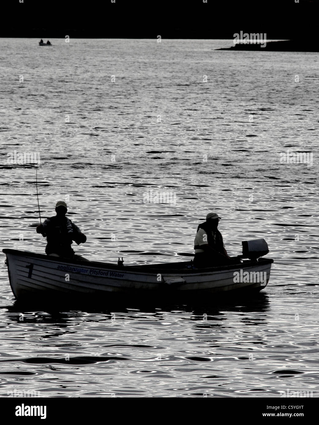 silhouette of two men in a motorboat fishing on a lake Stock Photo - Alamy