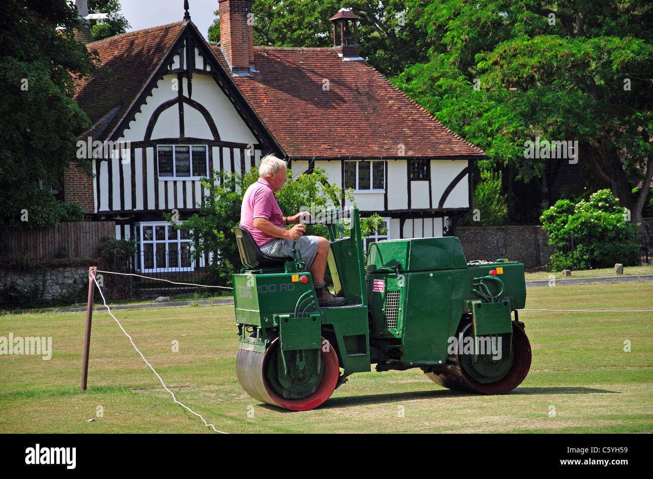 Man rolling cricket pitch on The Green, Bearsted, Maidstone District, Kent, England, United