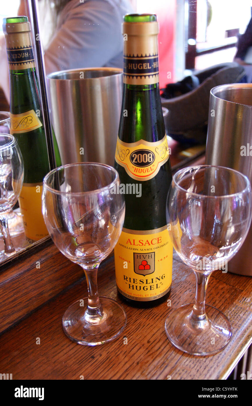 A bottle of Hugel Alsace Riesling white wine with two glasses at the French House bar, Dean Street, London pub table drinks glasses Stock Photo