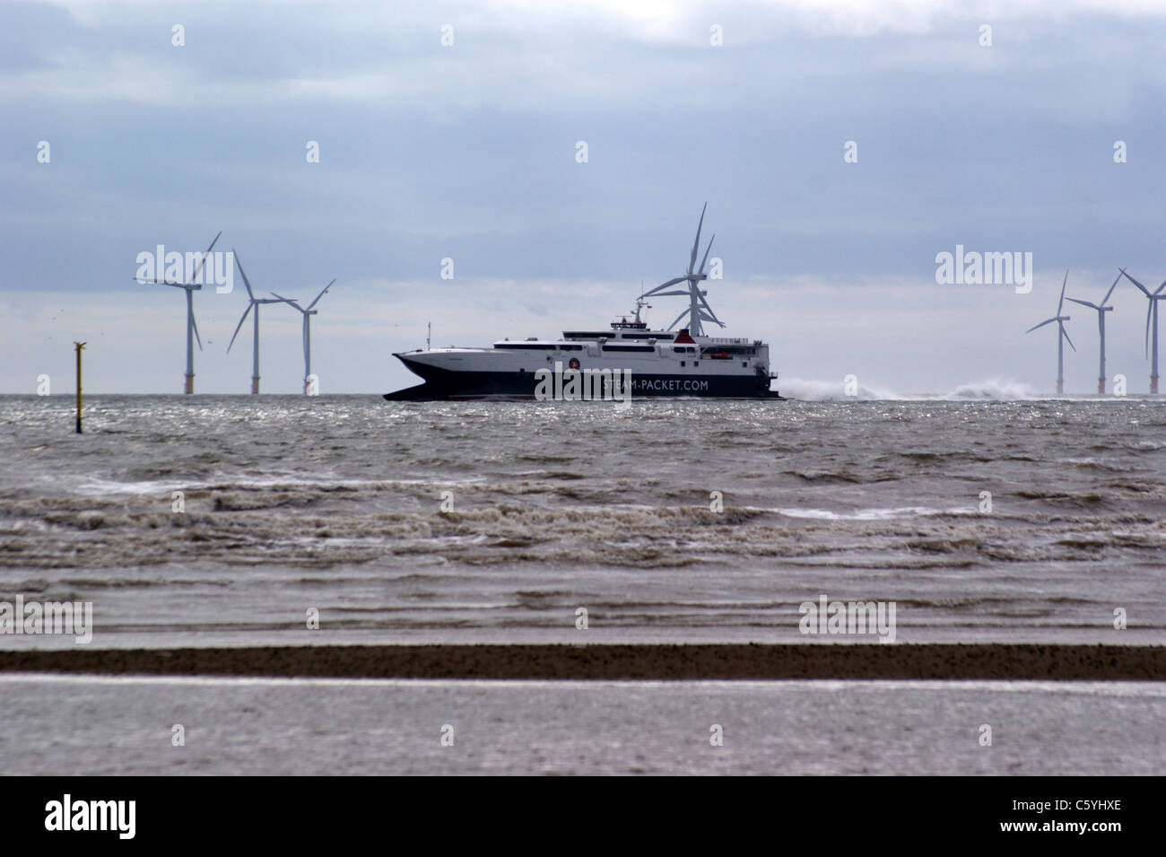 The Isle of Man ferry seen from Crosby beach, Liverpool, Merseyside, England, Liverpool wind farm in the background Stock Photo