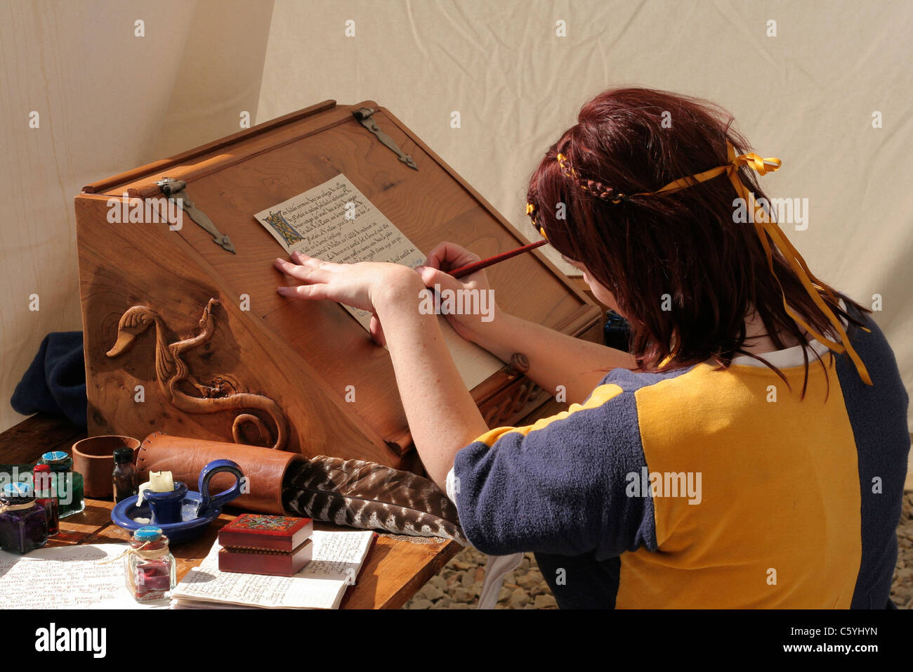 A woman writing with a quill on parchment, company la Chasse Arthus
