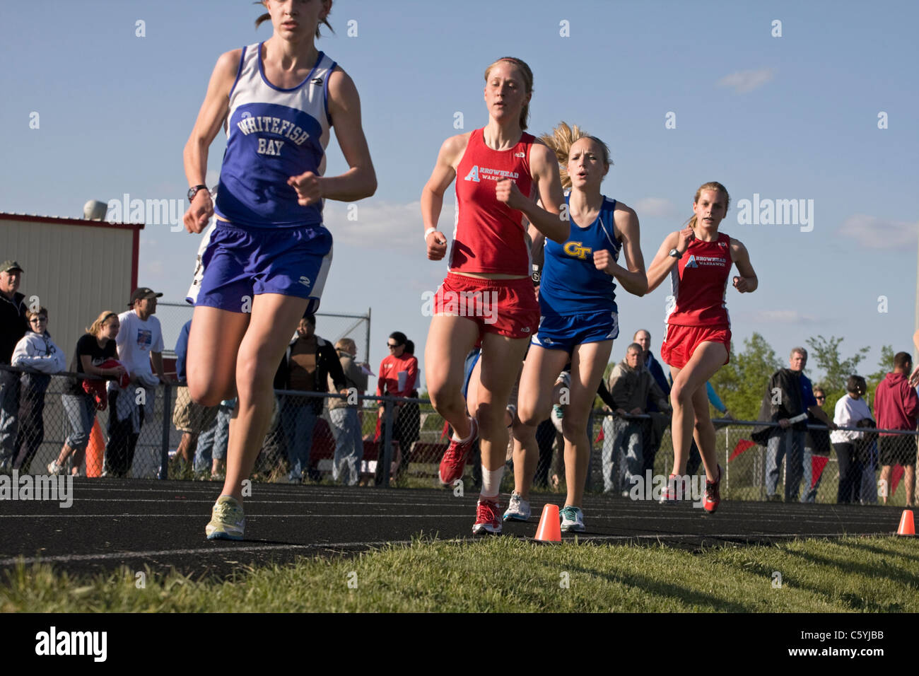 High school girls round the last turn at a sectional track meet in