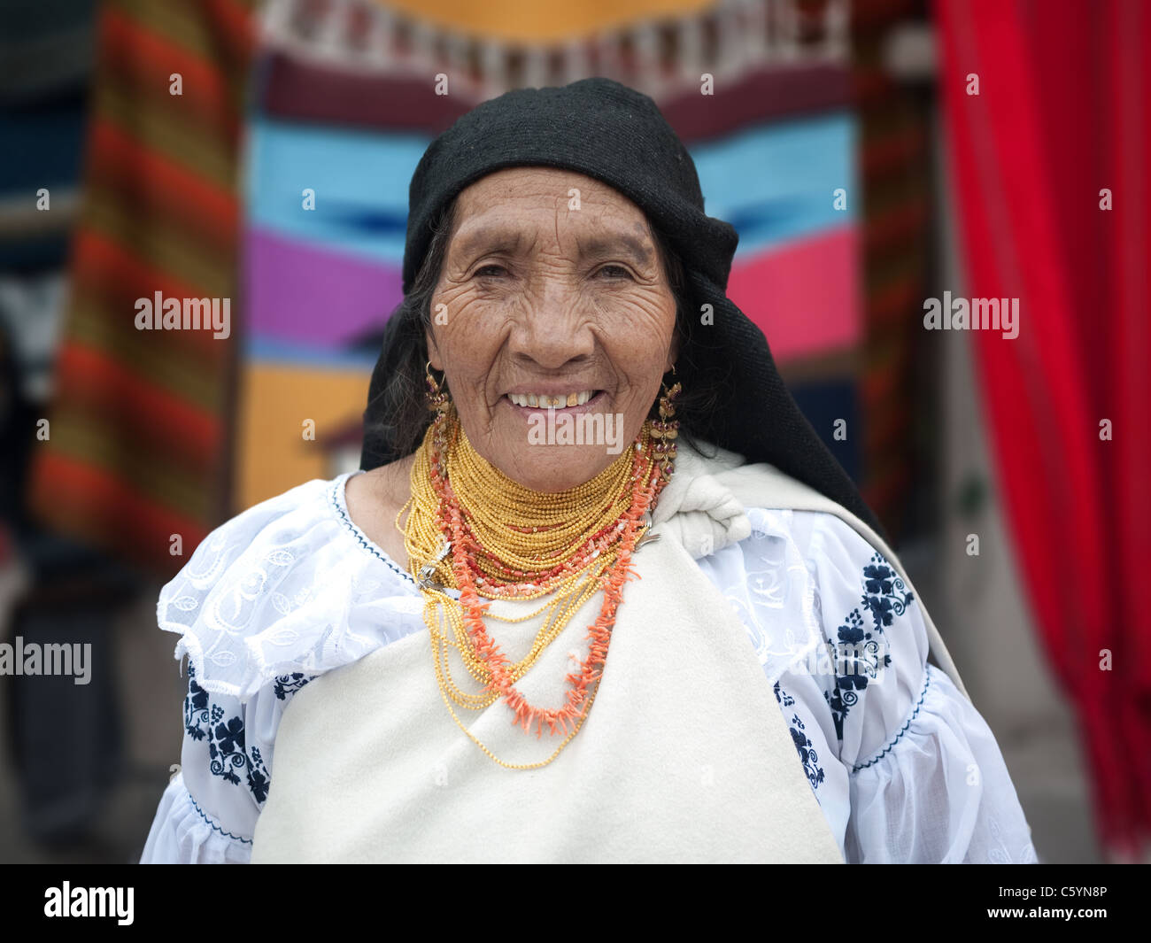 South American indigenous woman selling her hand-made crafts in the Otavalo Market in Ecuador. Stock Photo