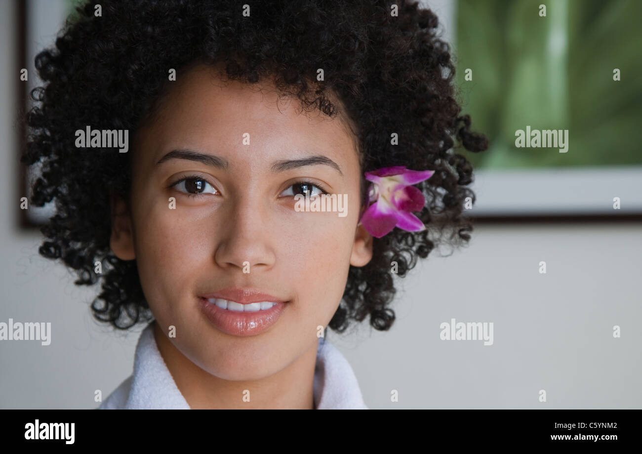 USA, California, Oakland, portrait of young woman with orchid in hair Stock Photo
