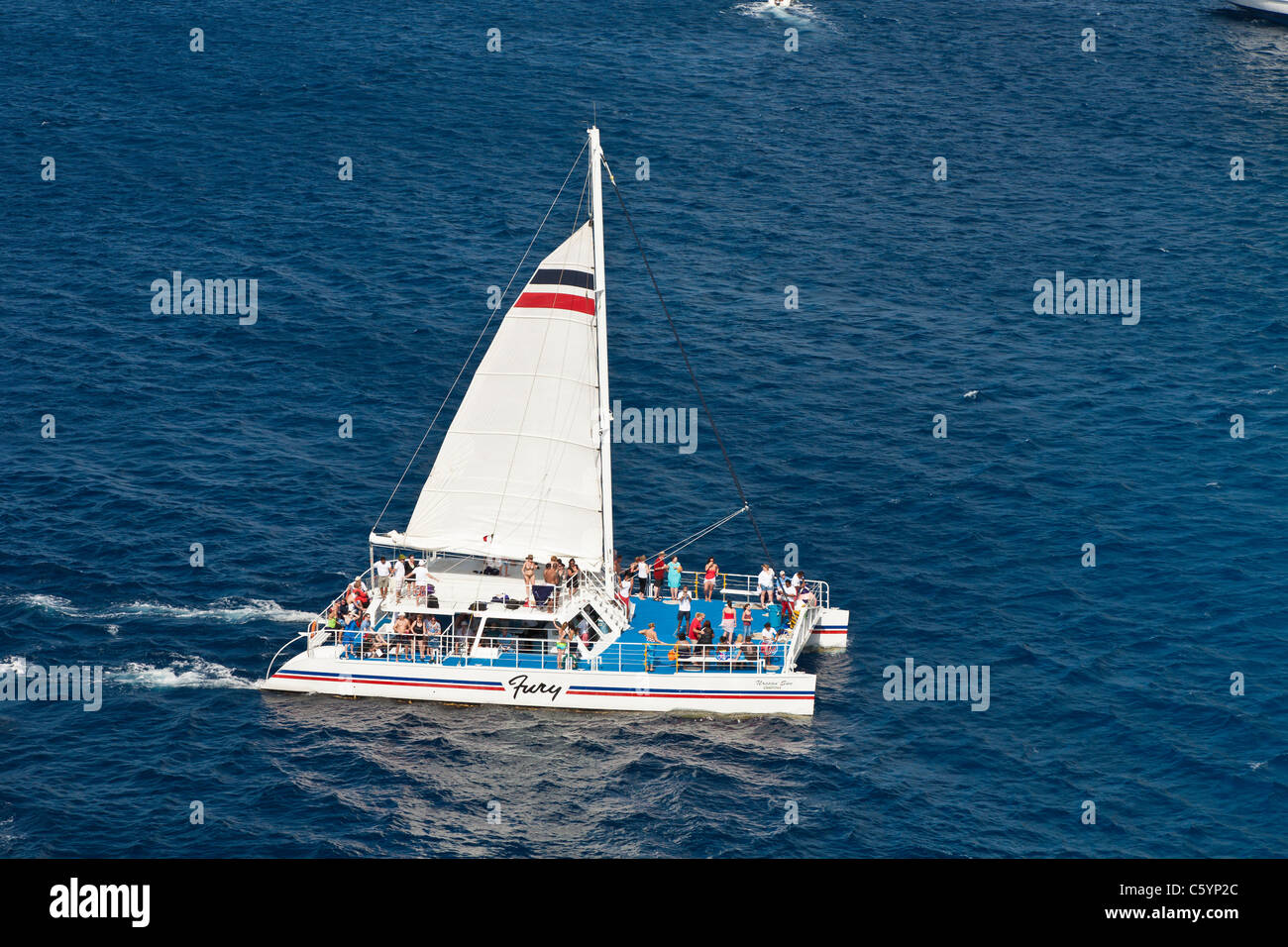 Sailing catamaran cruise excursion boat returns to dock in the Caribbean Sea off the coast of Cozumel, Mexico Stock Photo