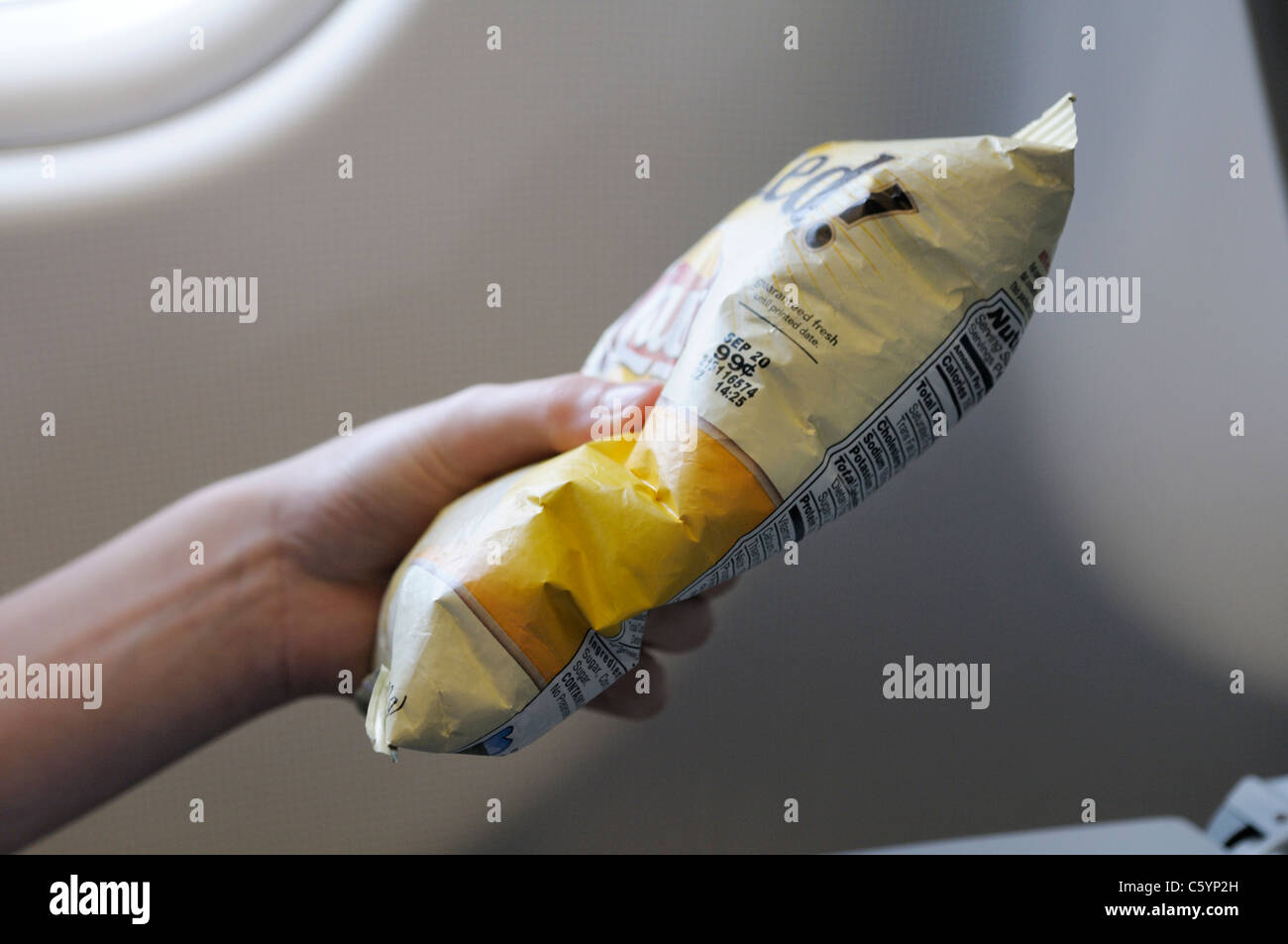 Chip bag on airplane at sea level showing effects of higher atmospheric pressure than in image # C5YP2N Stock Photo