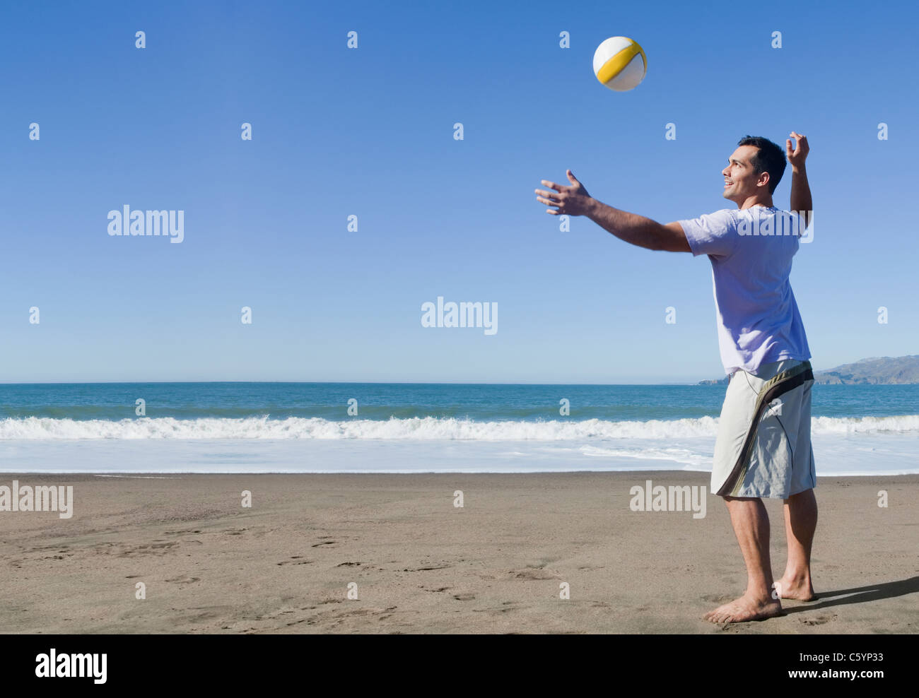 USA, California, San Francisco, man playing volley ball on Baker Beach