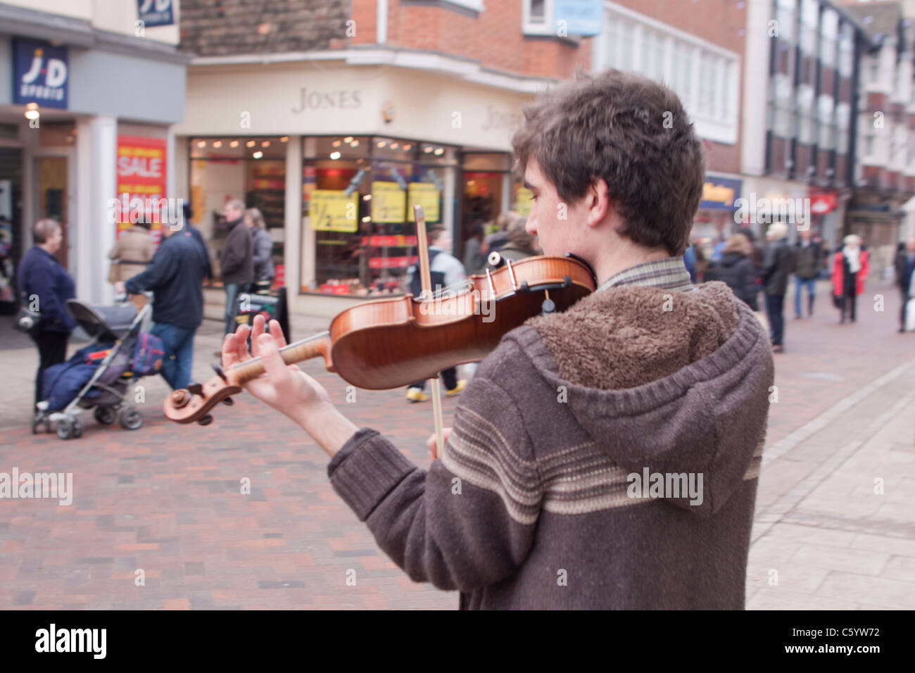 Busker playing a violin in the city of Canterbury, Kent. Stock Photo