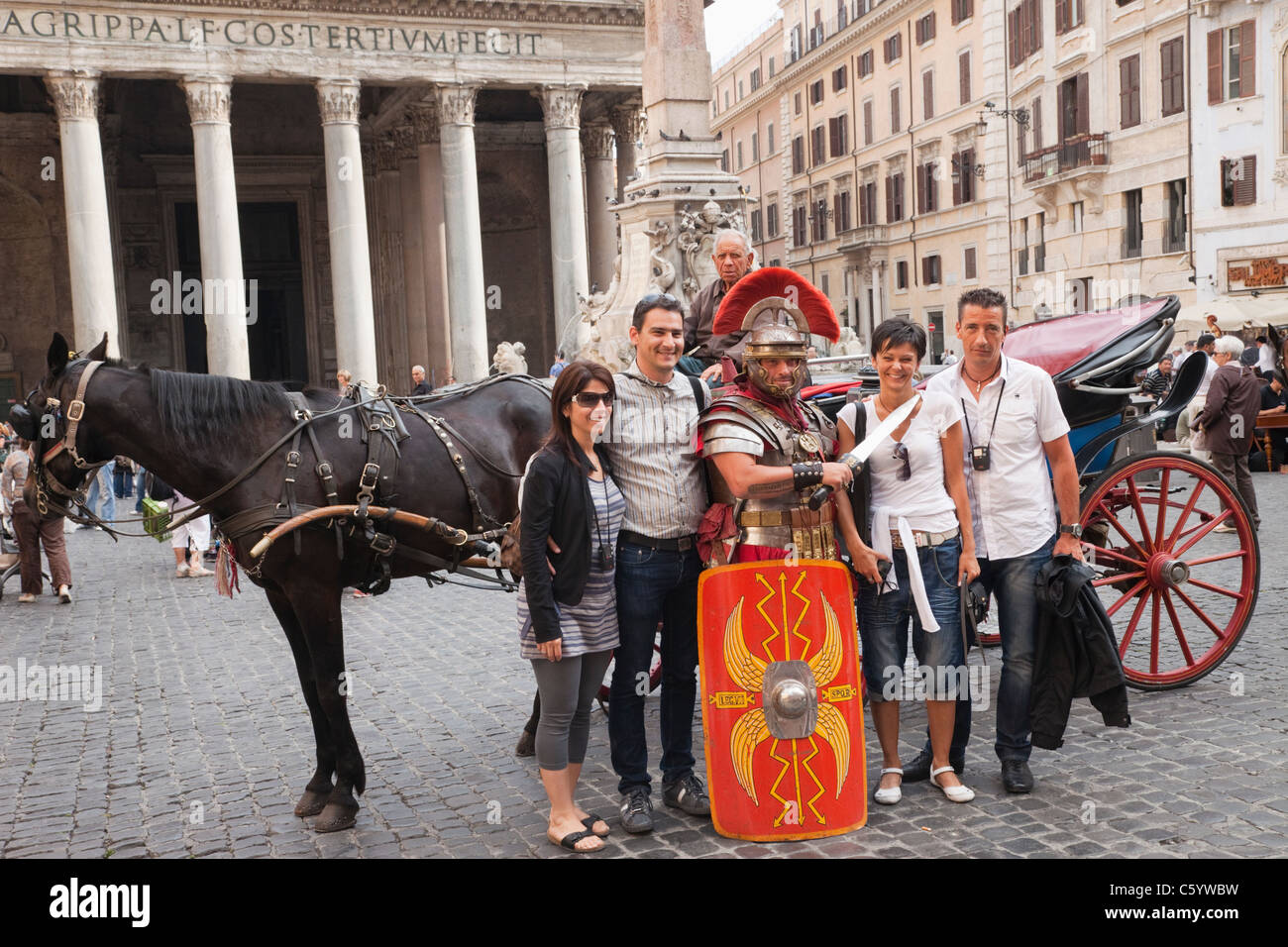 Italy, Rome, Tourists Posing with Man in Gladiator Costume Stock Photo