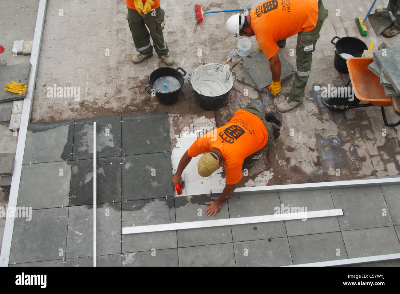 Spanish workmen laying paving stones Stock Photo Alamy