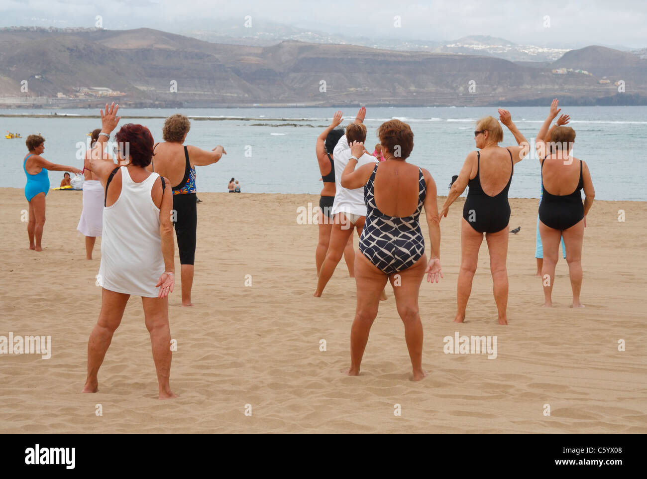 Elderly ladies exercise class on beach in Spain Stock Photo