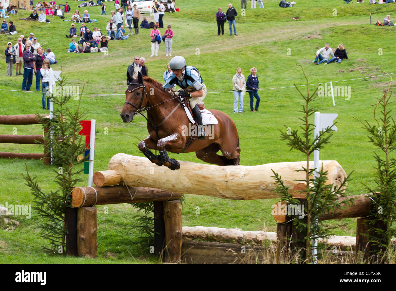 Horse and rider clearing a fence on the cross-country course at the British Festival of Eventing, Gatcombe Park Stock Photo