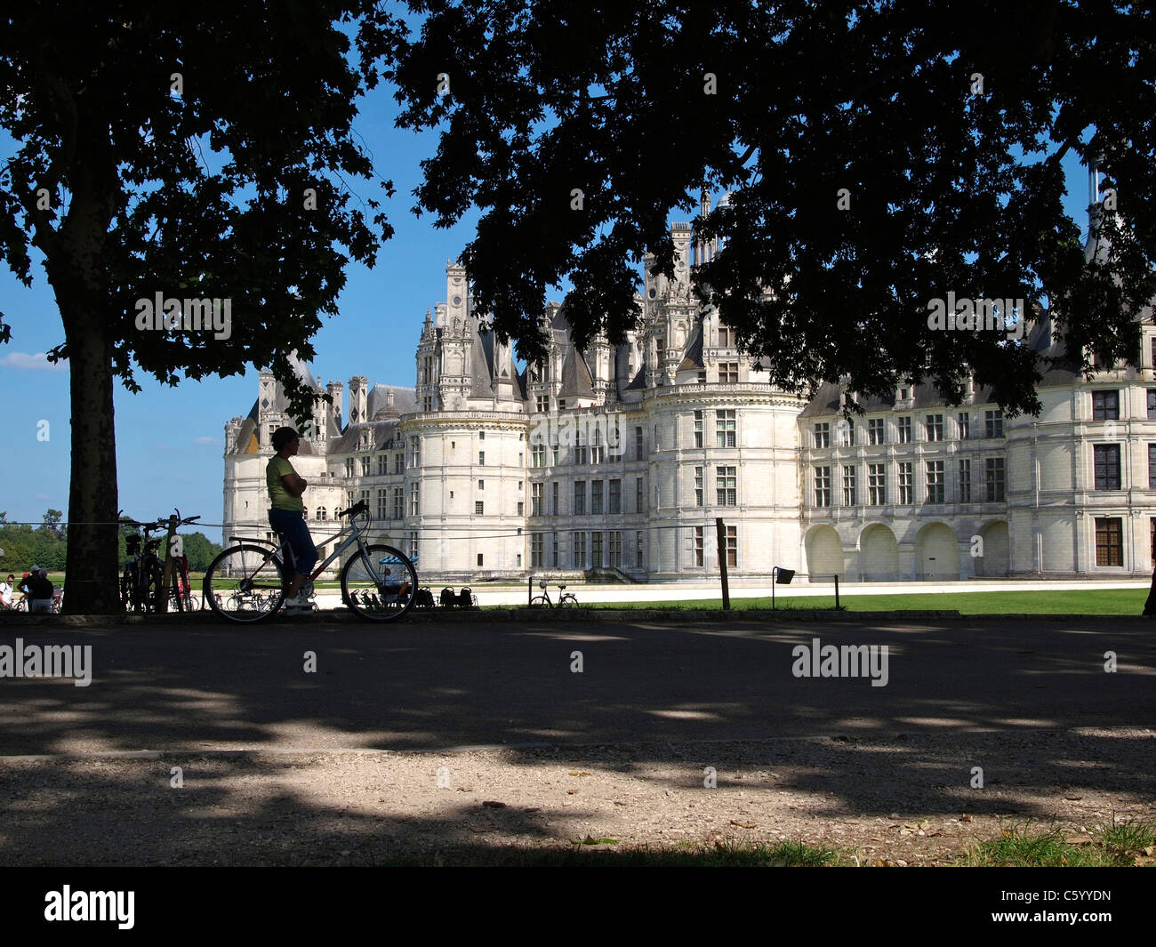 Woman cyclist looking at Chateau royal de Chambord, Loire valley, France Stock Photo